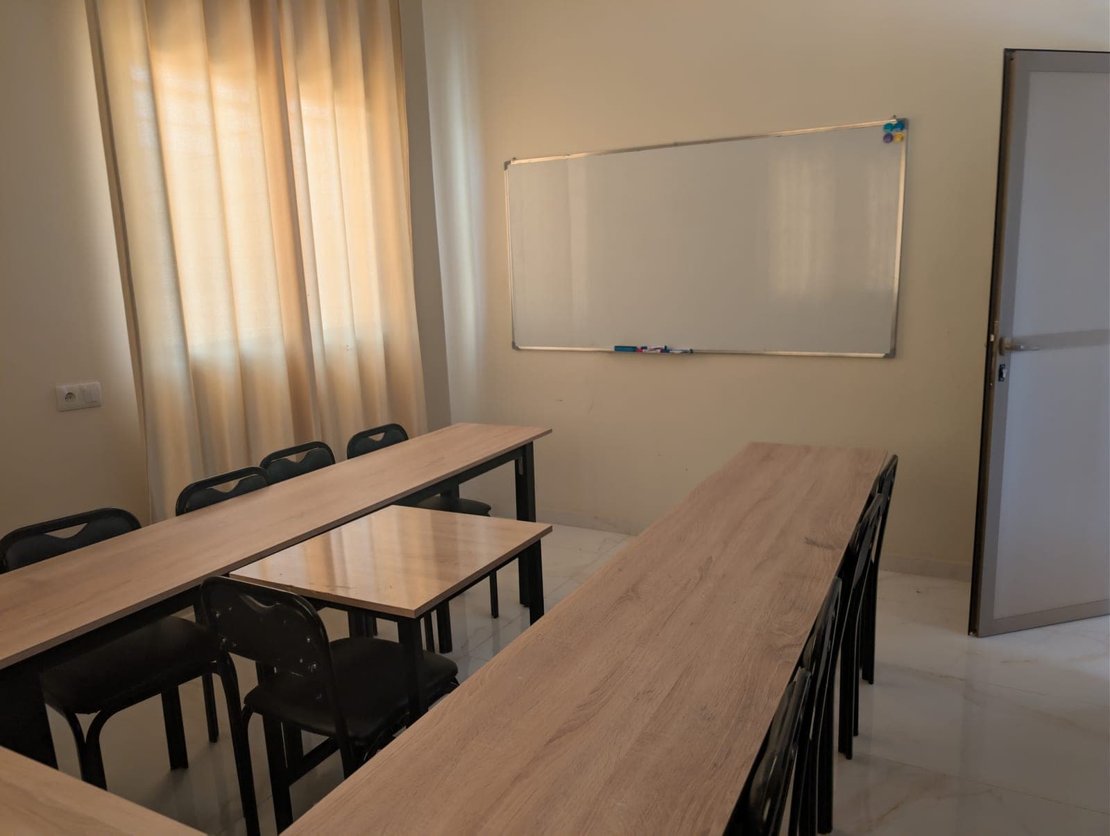 Classroom at Dialektika with rows of desks and a whiteboard