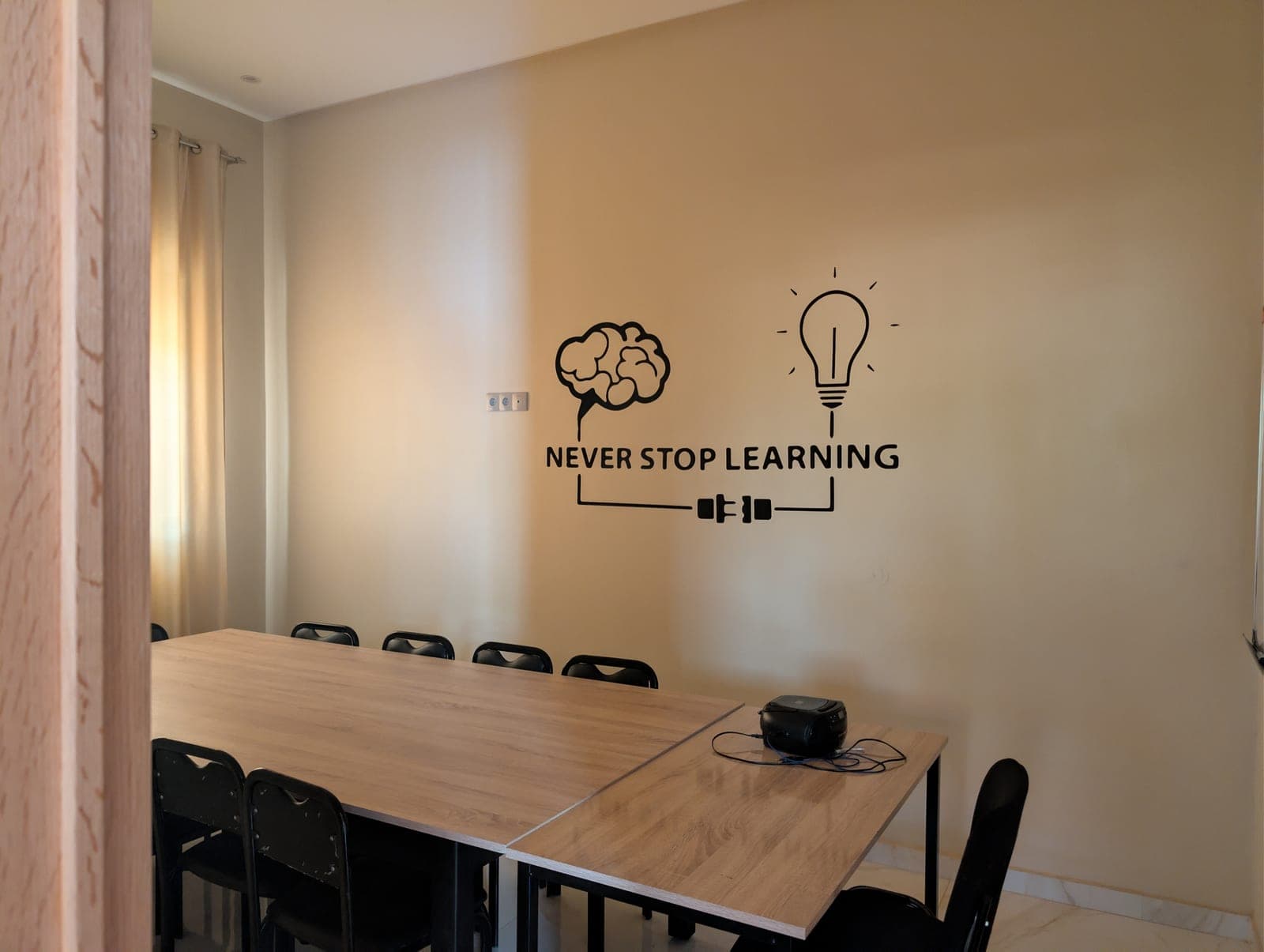 Training room at Dialektika with a 'Never Stop Learning' wall design